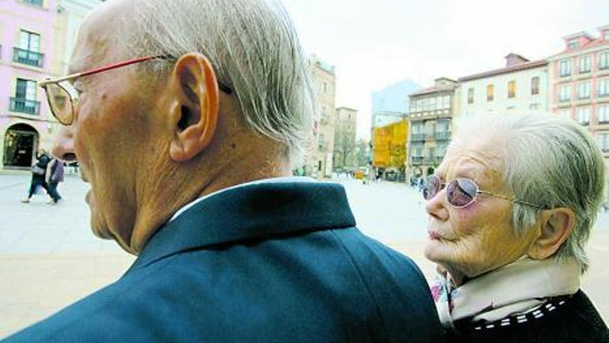 La pareja, sentada en un banco de la plaza de España de Avilés. | mara villamuza