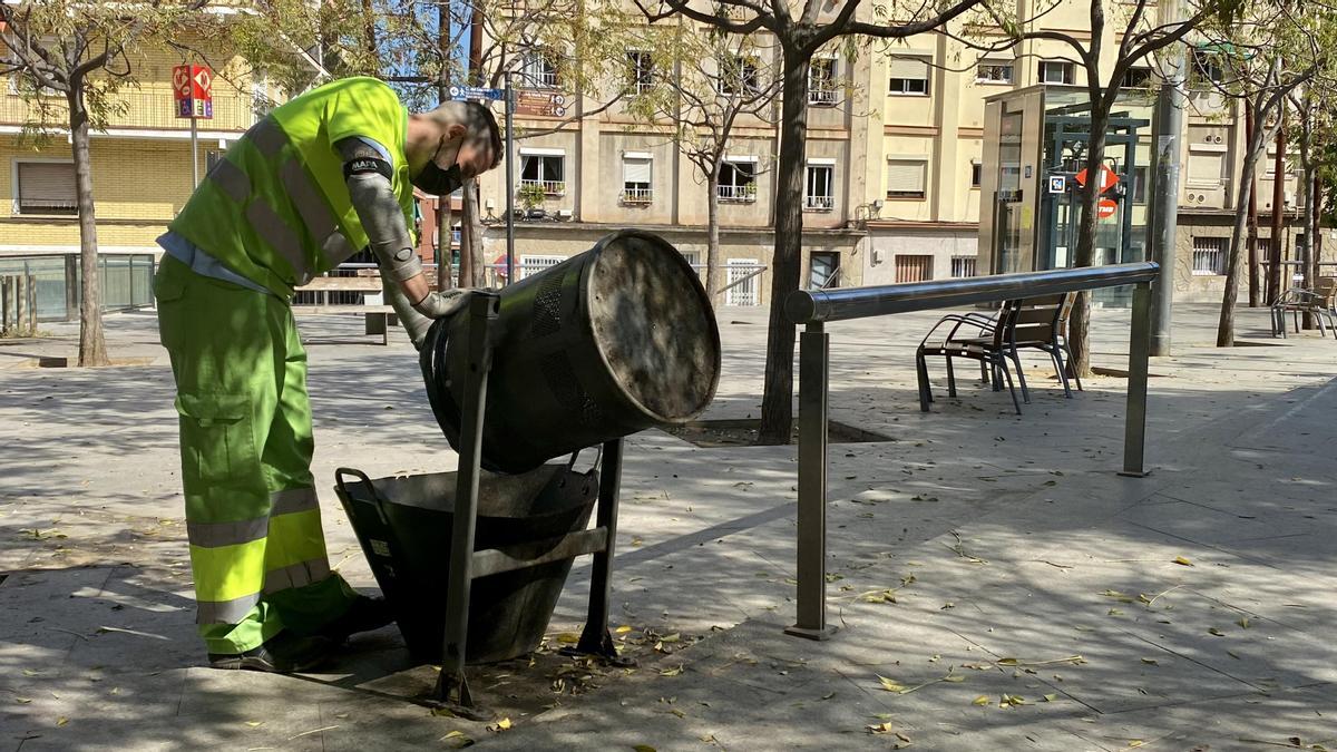 Aitor vacía una de las papeleras de la plaza de Pastrana, este viernes