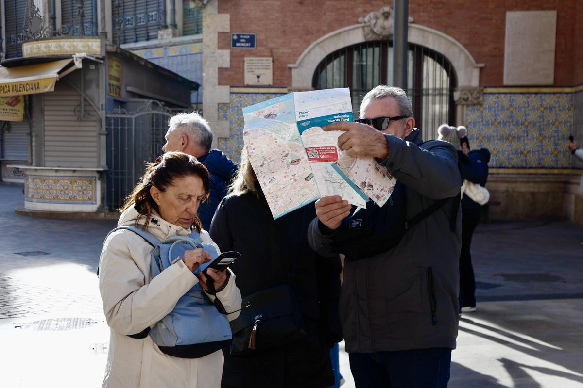 Visitantes consultan un mapa de la ciudad.