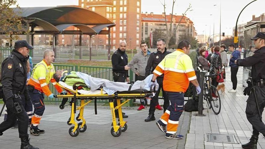 Los sanitarios trasladan a uno de los implicados en la trifulca ante la mirada del otro.