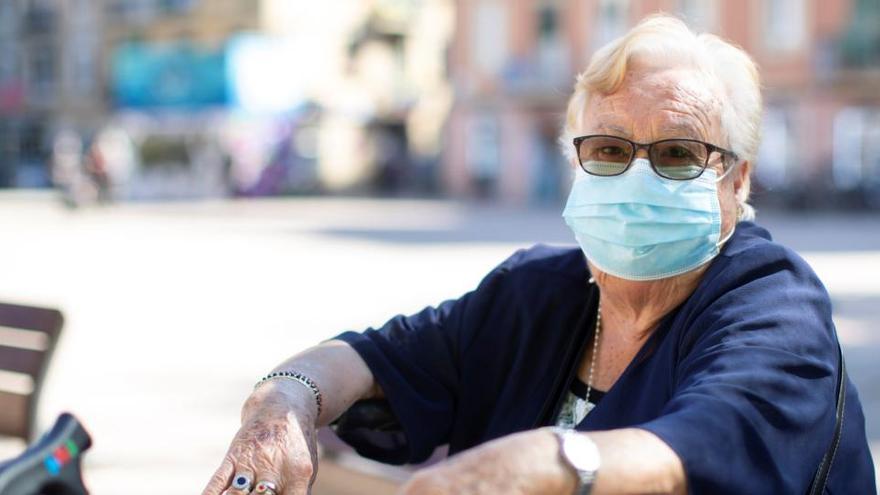 Una mujer con una mascarilla quirúrgica.