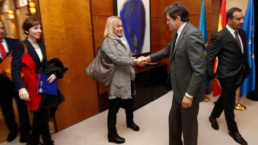 Javier Fernández estrecha la mano de Mercedes Fernández con la diputada popular Emma Ramos a la izquierda y el portavoz socialista, Fernando Lastra, a la derecha.