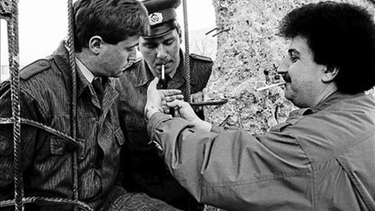 Tres hombres abren una brecha en el muro de Berlín, en 1990.