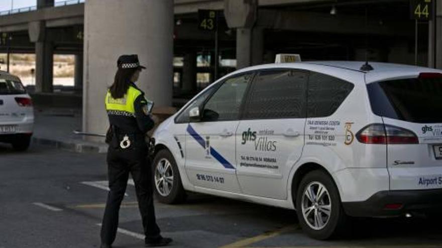 Una agente de la Policía Local de Elche se dirige hacia un taxi foráneo