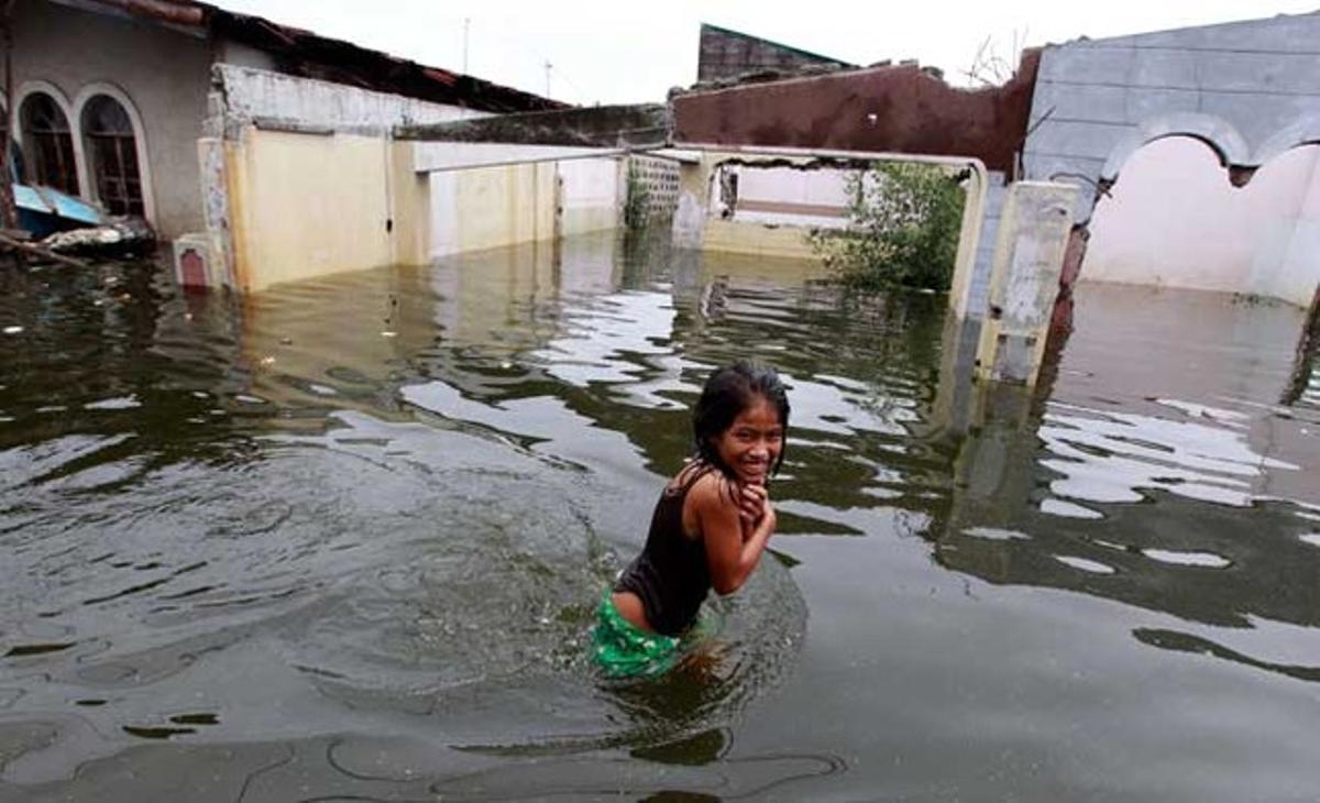 Una nena filipina camina pels carrers inundats de Dampalit, al nord de Manila. Més d’un milió de persones a les Filipines s’han vist afectades per les inundacions causades per la depressió tropical ’Egay’.