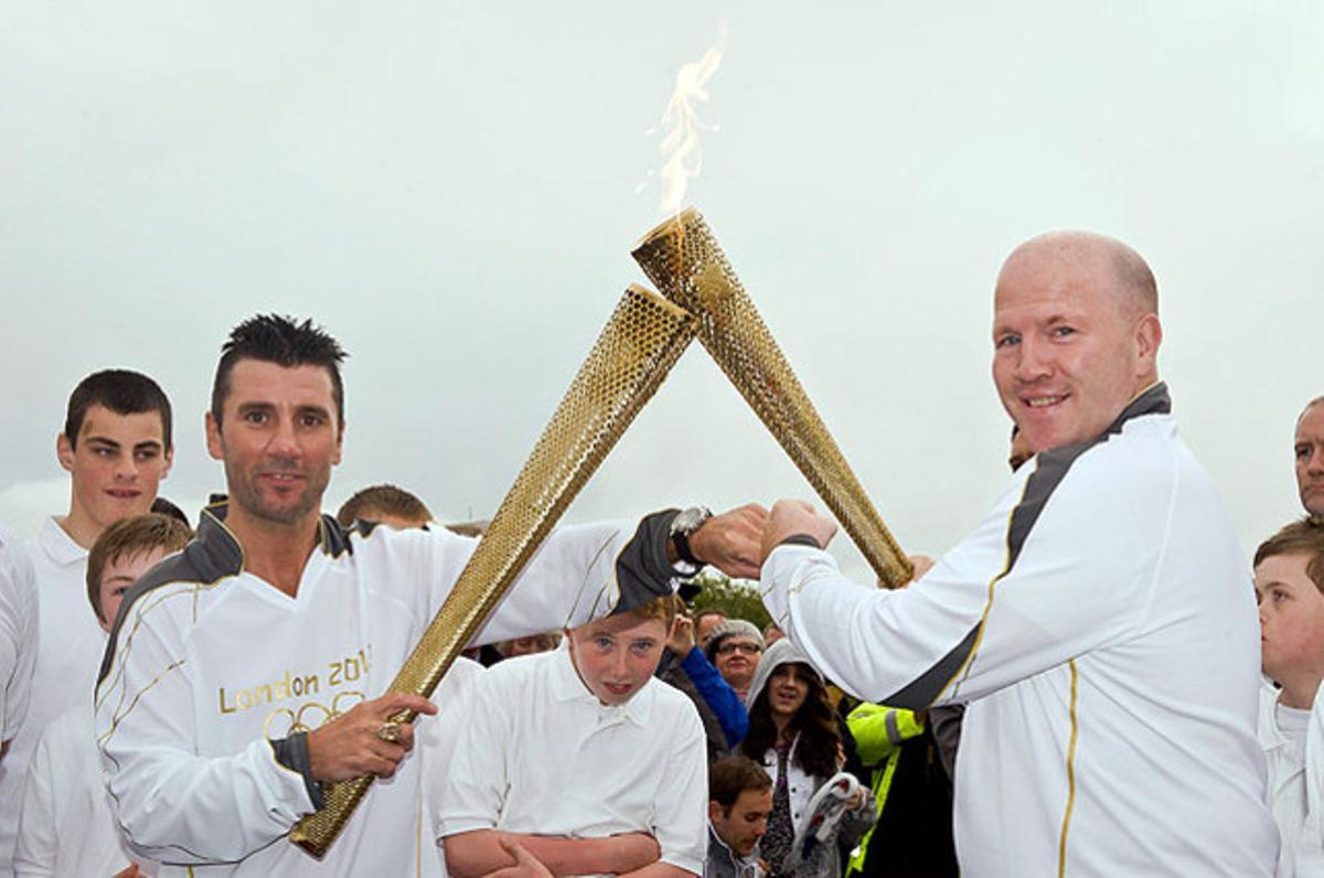 Els boxejadors irlandesos Wayne McCullough (esquerra) i Michael Carruth es relleven com a portadors de la flama olímpica a la frontera entre Newry (Irlanda del Nord) i Dundalk (Irlanda).