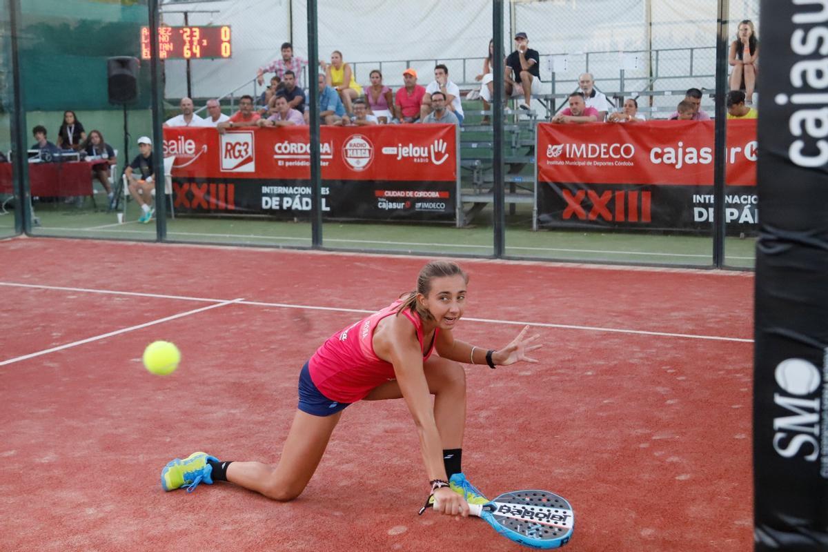 Una jugadora golpea una bola en un encuentro de pádel.