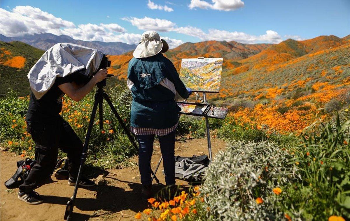 Un hombre retrata a una mujer que pinta en las colinas del cañón Walker, cerca del lago Elsinore, California.