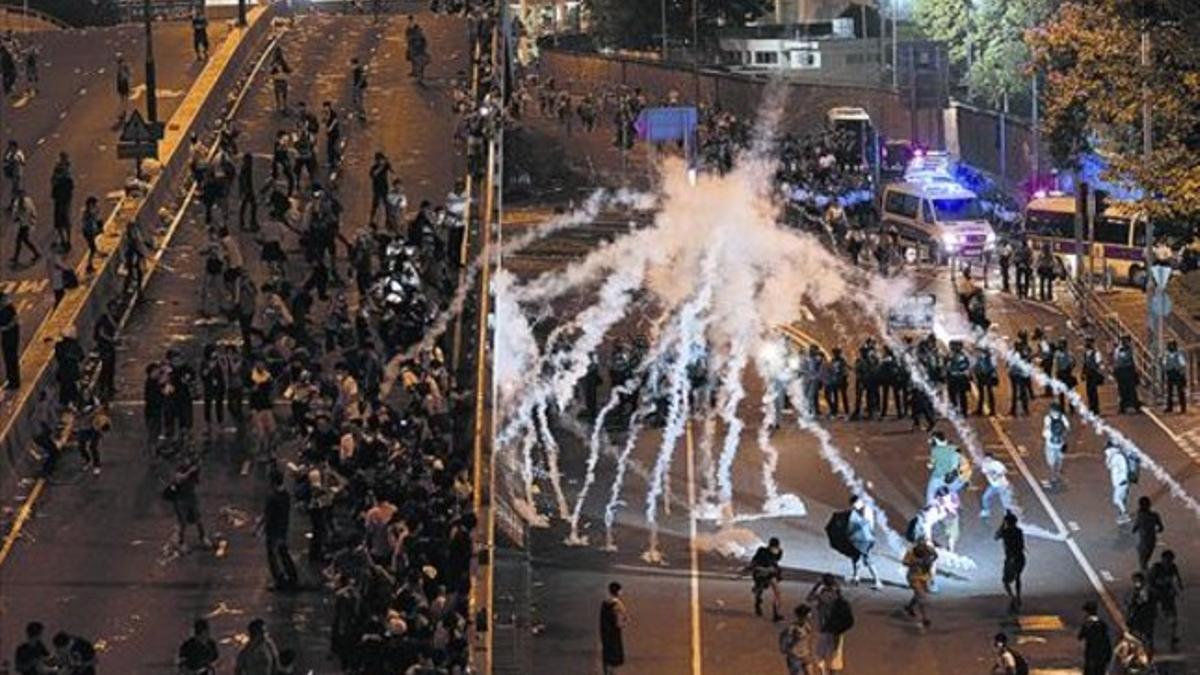 La policía emplea gas lacrimógeno contra los manifestantes en el distrito gubernamental de Hong Kong, en la madrugada del lunes.