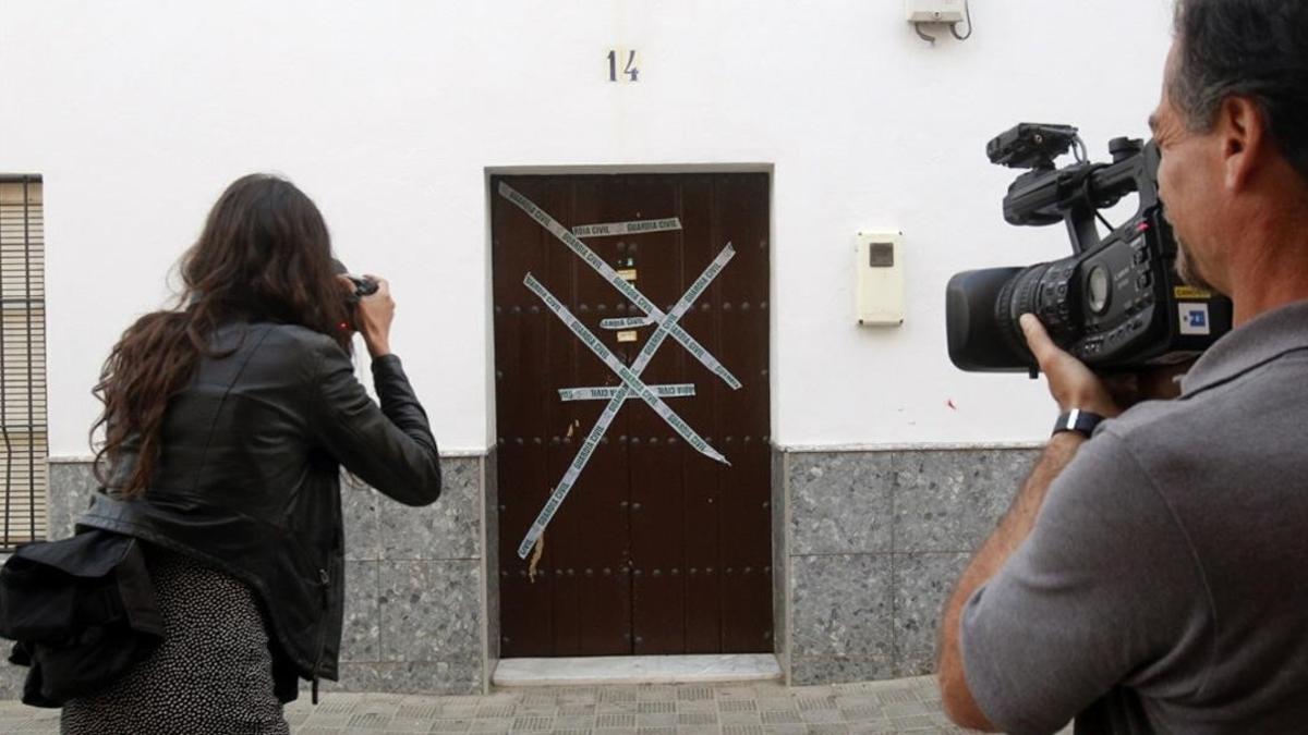 Periodistas tomen fotos ante la vivienda que compartían agresor y víctima en Alcolea del Río, en Sevilla.