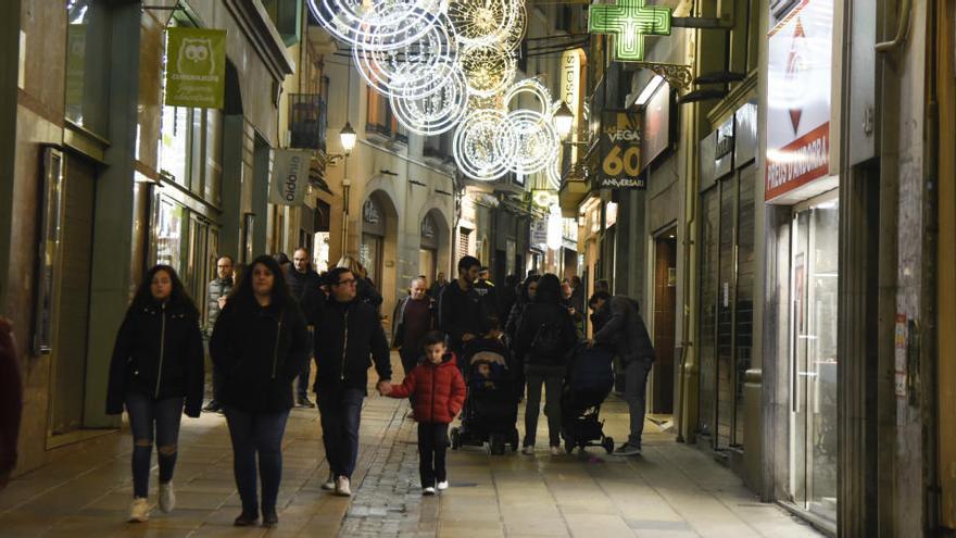 Persones passegen pel carrer Nou de Manresa, il·luminat pels llums de Nadal