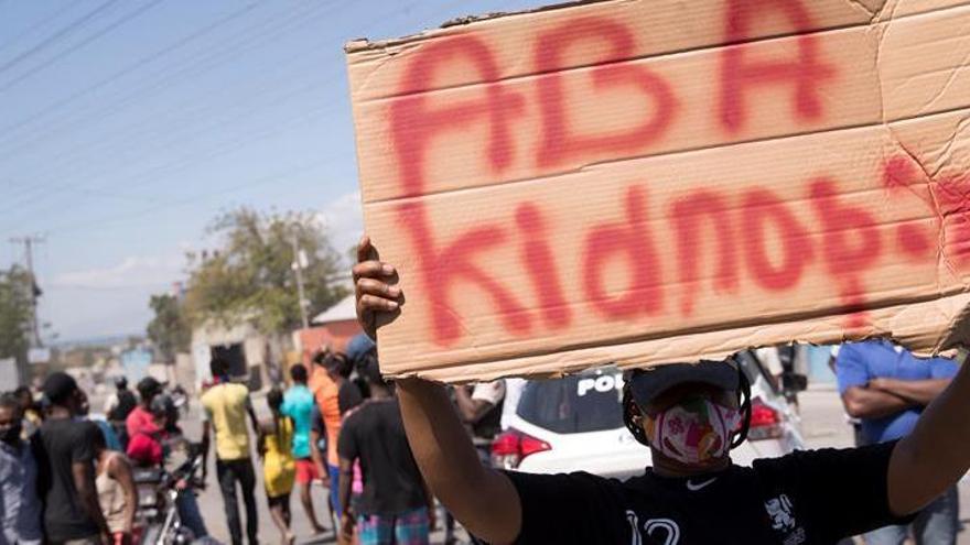 Un grupo de manifestantes grita arengas y carga letreros con la frase &quot;Abajo los secuestros&quot; en Haití.