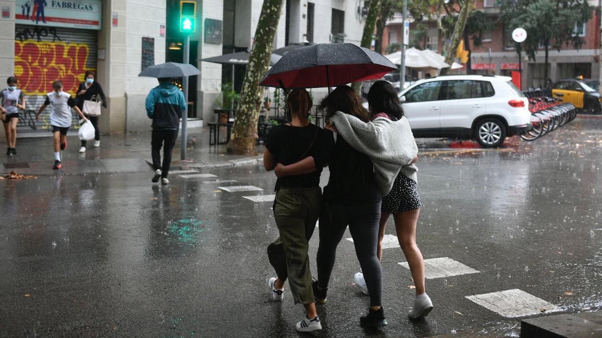 Paraguas bajo la lluvia esta tarde en la ciudad.