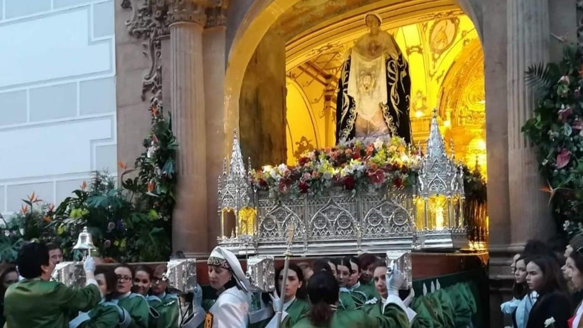 Carmen Casalduero de mayordomo, centro, con el trono de la Verónica mientras éste cruza el umbral de la capilla del Rosario.