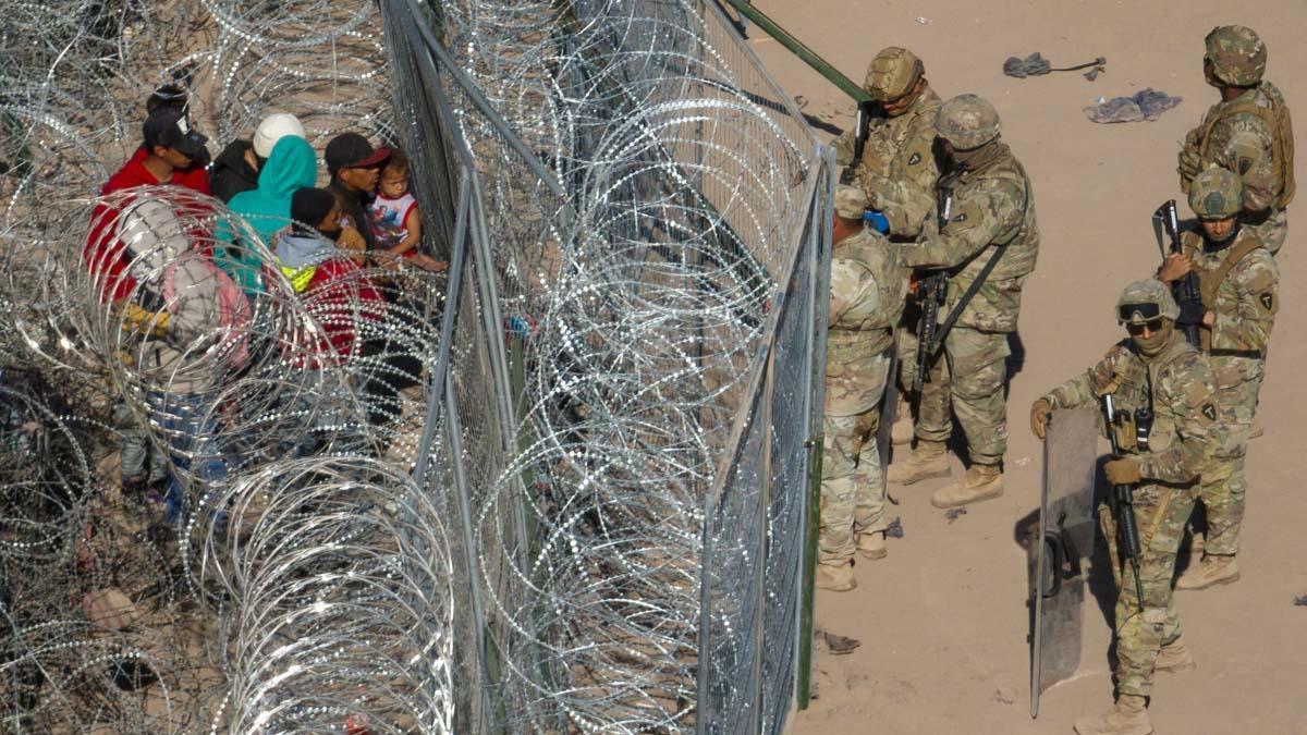 Migrantes acampan a lo largo de la orilla del río Grande mientras esperan entregarse a las autoridades de inmigración en El Paso, Texas, EE.UU