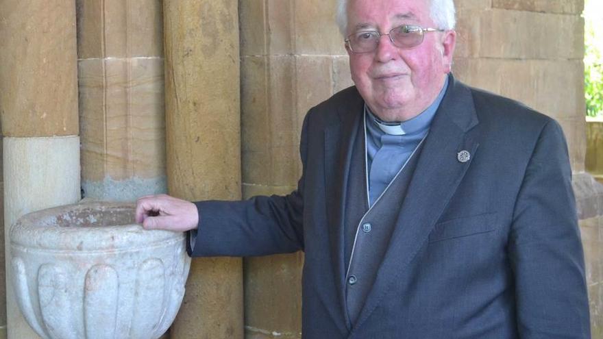 Agustín Hevia Ballina junto a una pila de la iglesia de Santa María de Lugás.