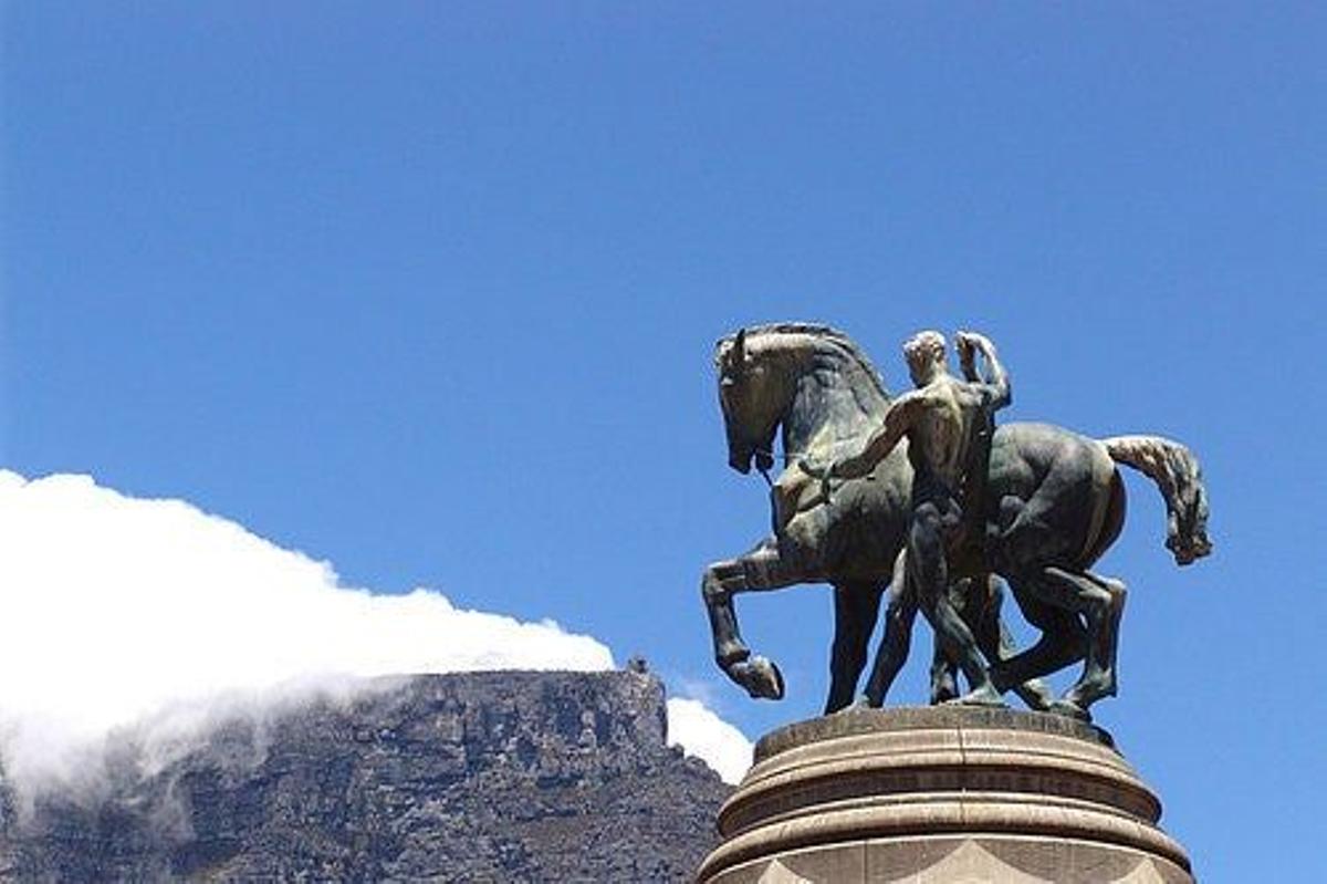 Estatua en Ciudad del Cabo con la Montaña de la Mesa al fondo.