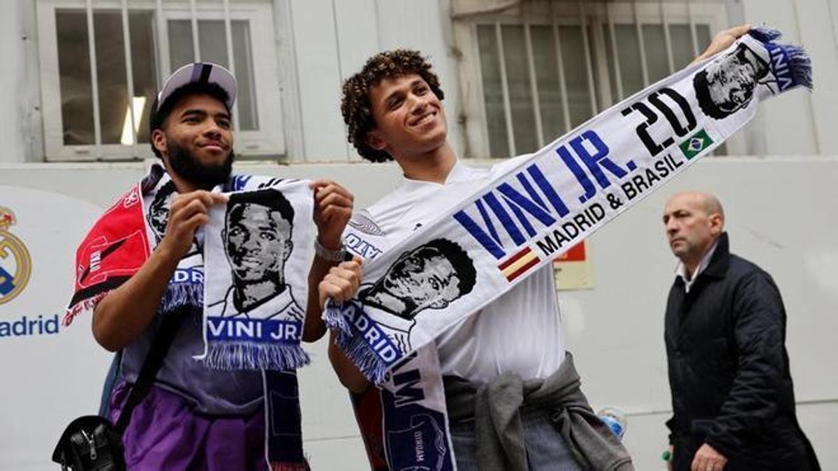 Aficionados del Real Madrid con banderas y bufandas de Vinicius. 