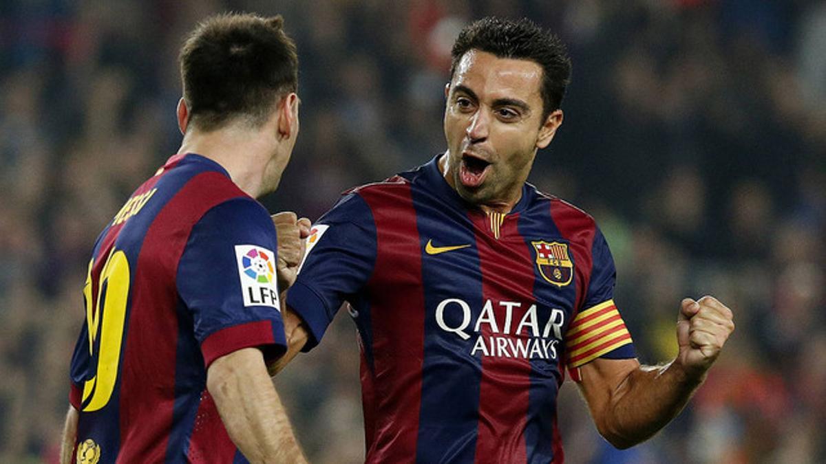 Xavi festeja con Messi uno de los goles del delantero argentino