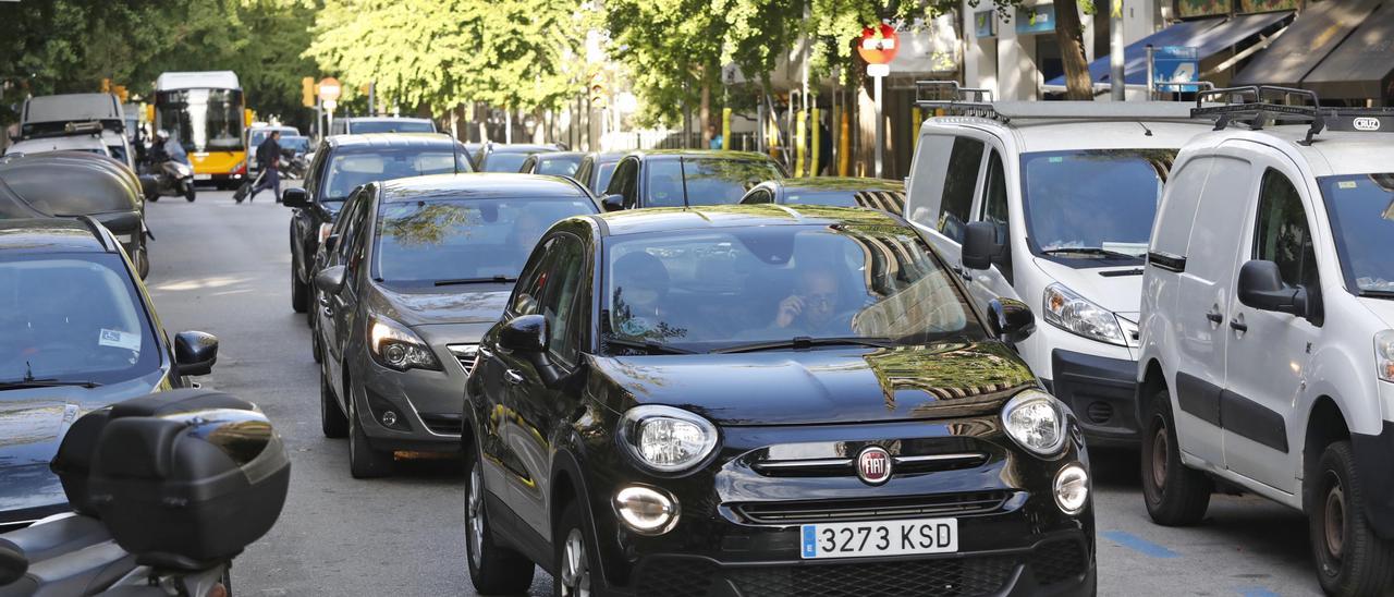 Cotxes esperant al semàfor de la cruïlla entre el carrer de la Creu i el carrer Migdia