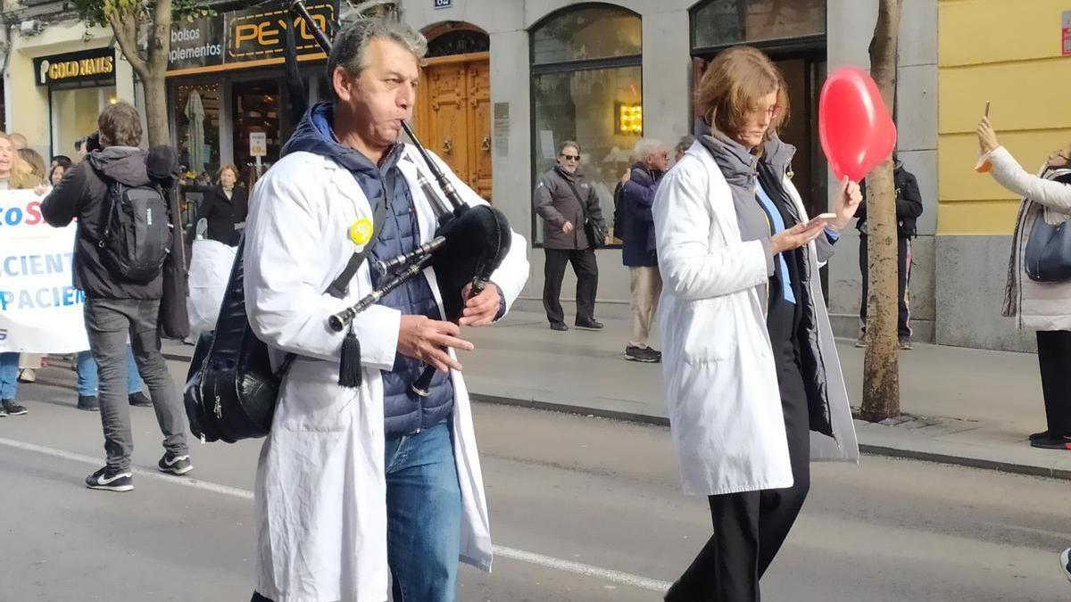 Un médico toca la gaita durante una marcha en Madrid.