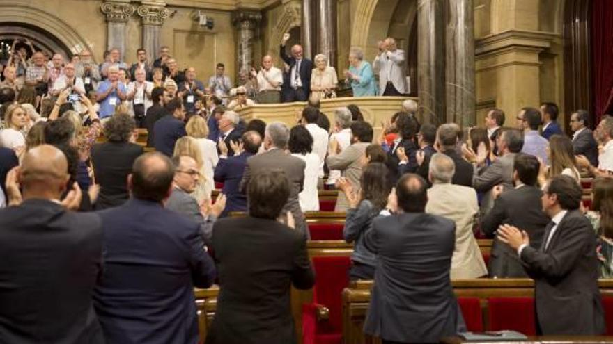 Els diputats aplaudeixen representants de les víctimes.