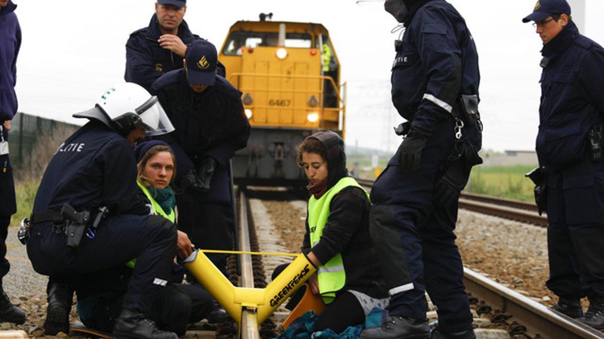 Policías holandeses tratan de despejar las vías ferroviarias en Borsele, donde se habían encadenado dos activistas de Greenpeace.