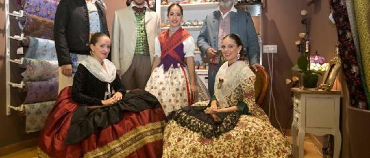 Seis foguerers visten los trajes reglamentarios masculinos y femeninos de faena, algodón y de mudar, en la tienda de indumentaria de Conchi Beneyto.