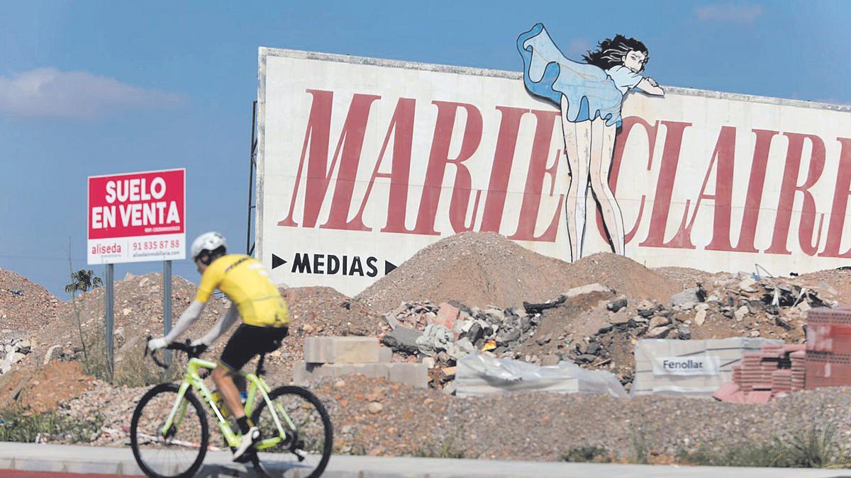 Un ciclista pasa frente a un cartel publicitario de Marie Claire en la avenida Castell Vell de Castelló (antigua N-340).