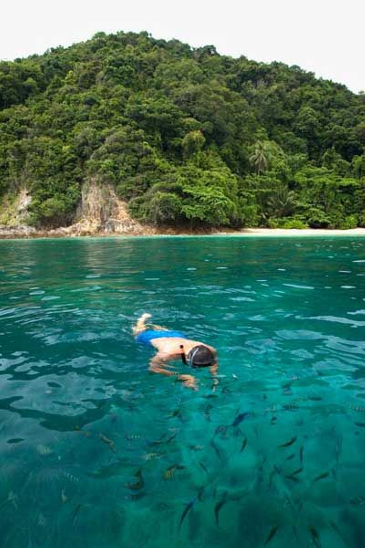 Hombre practicando snorkel en la isla de Palau Kapas.