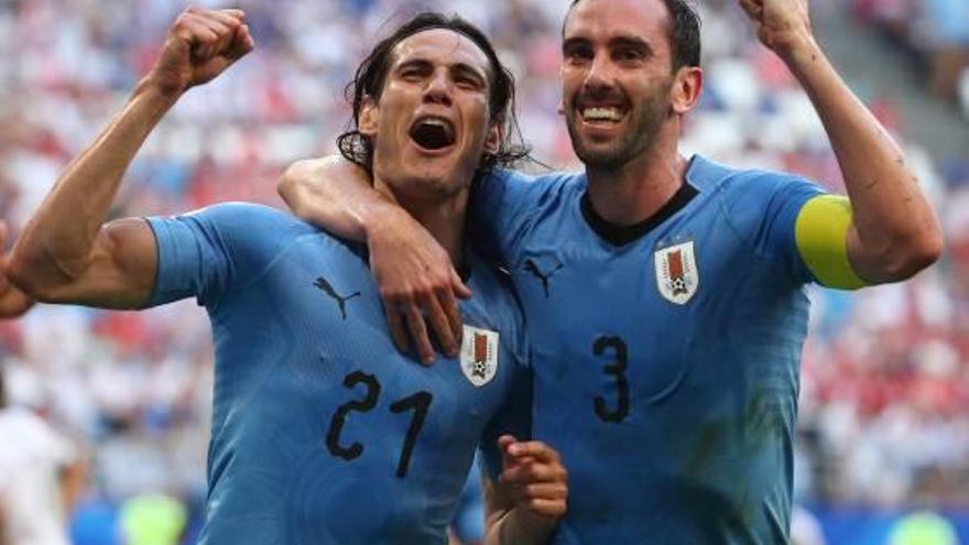 Los uruguayos Cavani y Godín celebran el tercer gol de su selección frente a Rusia.