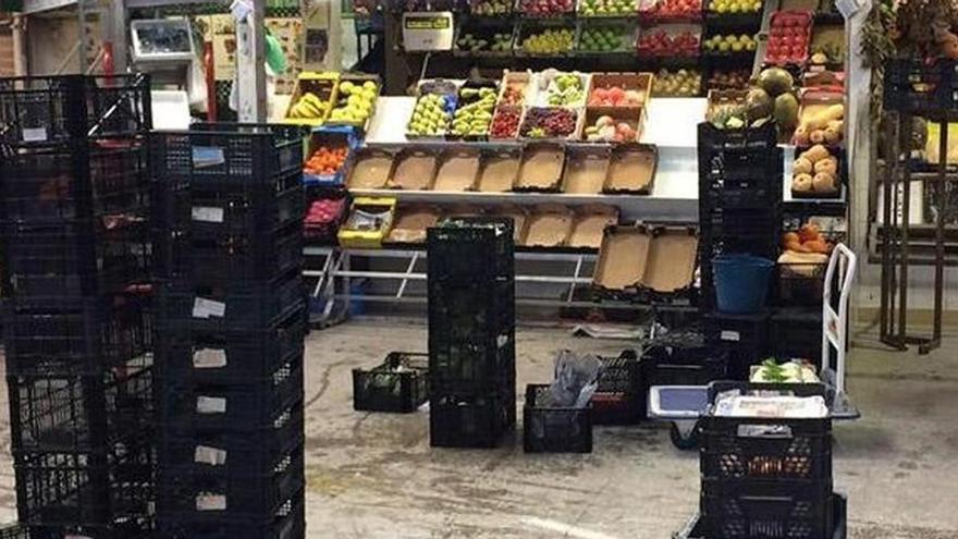 Mercancías de frutas y verduras apiladas ante la entrada de agua en el mercado municipal de Marbella