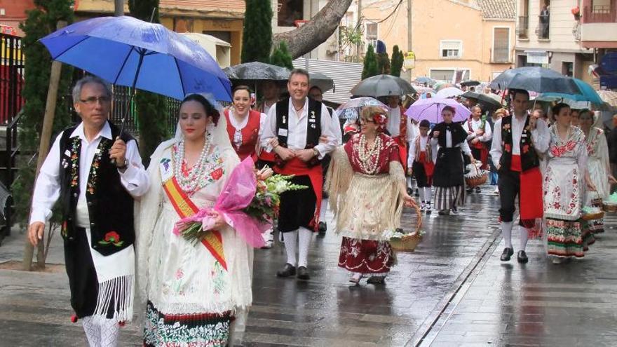 Los participantes en el desfile, que terminó suspendiéndose, tuvieron que usar paraguas.