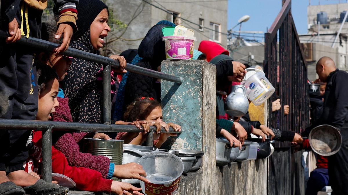 Largas filas de niños y niñas de Palestina para recibir comida en la frontera de Gaza