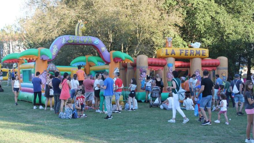 Jóvenes acompañados por sus familias disfrutando de los hinchables de la Volta ao Cole en Ames