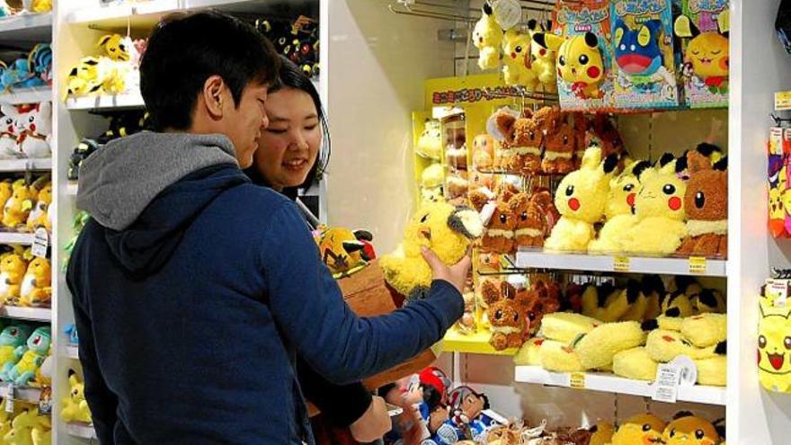 Una parella mira un peluix de Pikachu al Pokémon Center Mega Tòquio