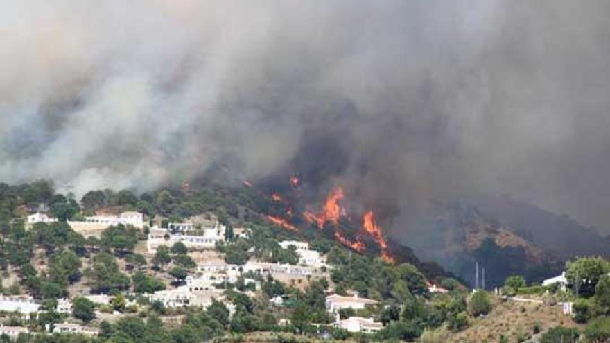 La localidad de Cómpeta, rodeada por el fuego.