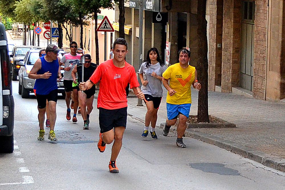 Pas dels esportistes suriencs amb la Flama del Canigó per l'avinguda de l'Ajuntament, dins de la celebració de la Nit de Sant Joan a Súria