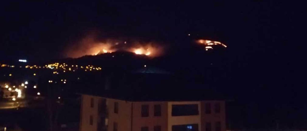 Incendio en el bosque de Cardes (Piloña) visto desde el barrio de Xudes, en Infiesto, el domingo.