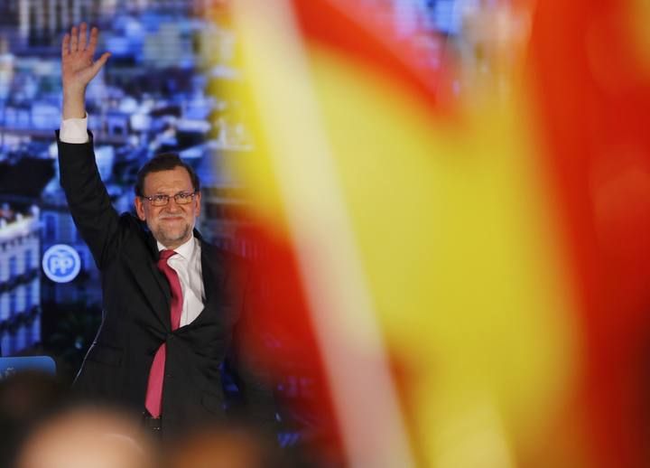 Spanish Prime Minister and People's Party (PP) leader Mariano Rajoy raises his arm after delivering a speech at a campaign rally ahead of Spain's general election in Valencia