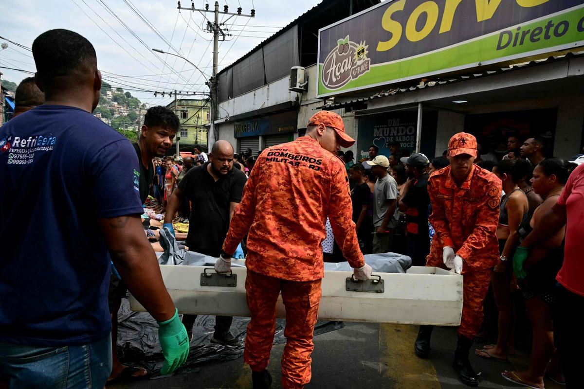 EDITORS NOTE: Graphic content / Firefighters and residents carry a body on Sao Lucas Square of the Vila Cruzeiro favela at the Penha complex in Rio de Janeiro, Brazil, on October 29, 2025, in the aftermath of Operacao Contencao (Operation Containment). Residents of a favela in Rio de Janeiro lined up more than 50 bodies at a plaza in their low-income neighborhood on Ocotber 29, a day after the bloodiest police operation in the citys history, AFP reported. (Photo by Pablo PORCIUNCULA / AFP). Graphic content