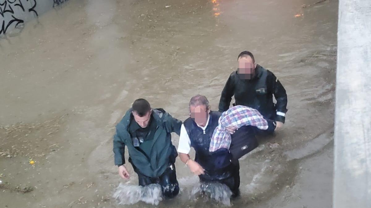 El conductor del autobús escolar atrapado en les Alqueries junto a los agentes de la Guardia Civil que evacuaron el vehículo.