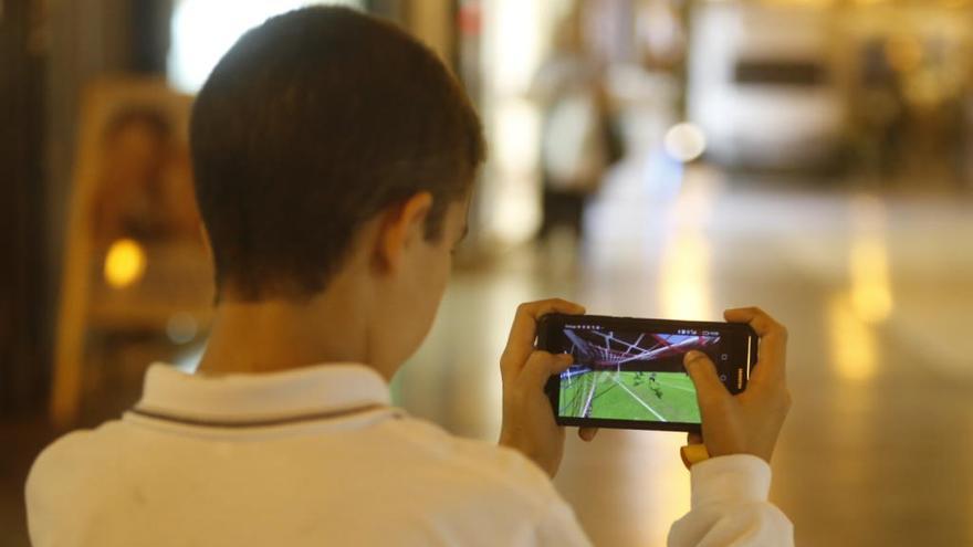 Un niño jugando con un teléfono móvil.