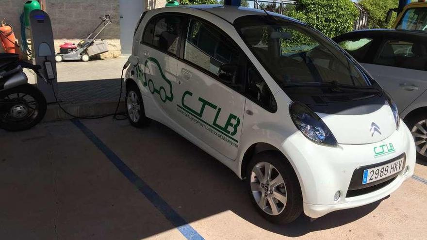 Un automóvil eléctrico, recargando las baterías en un poste de repostaje.