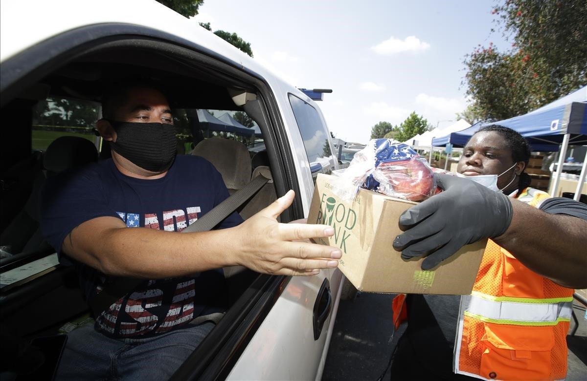 Jeremiah Washington, distribuye alimentos. Las cifras de desempleo continúan aumentando y más estadounidenses recurren a la distribución de alimentos en medio de la pandemia.