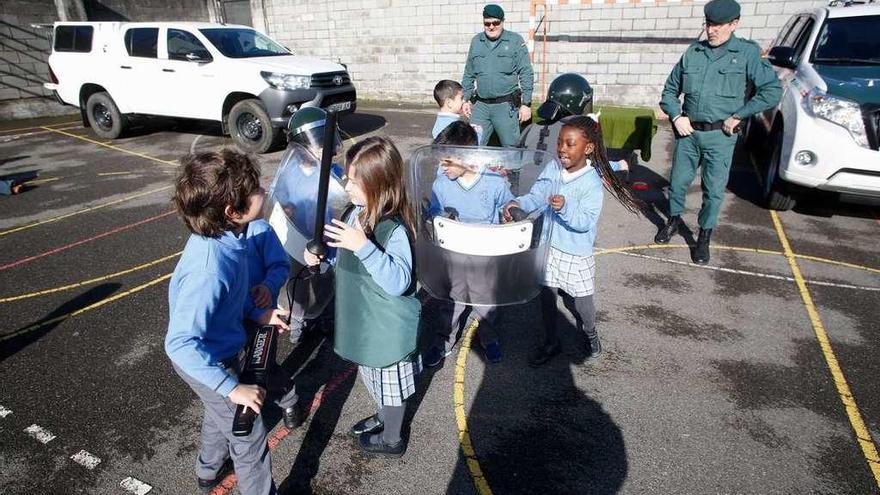 Un grupo de alumnos juega con el equipamiento de la Benemérita de Gijón.