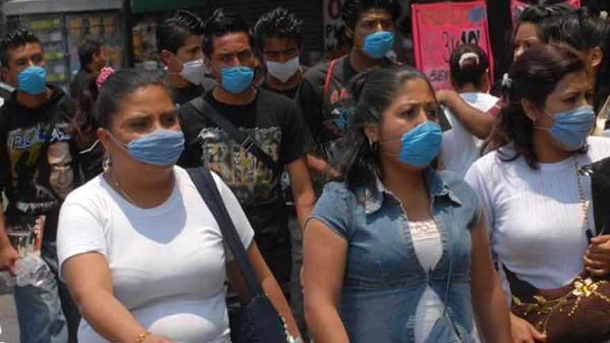 Ciudadanos mexicanos usan mascarillas en una calle de Ciudad de México.