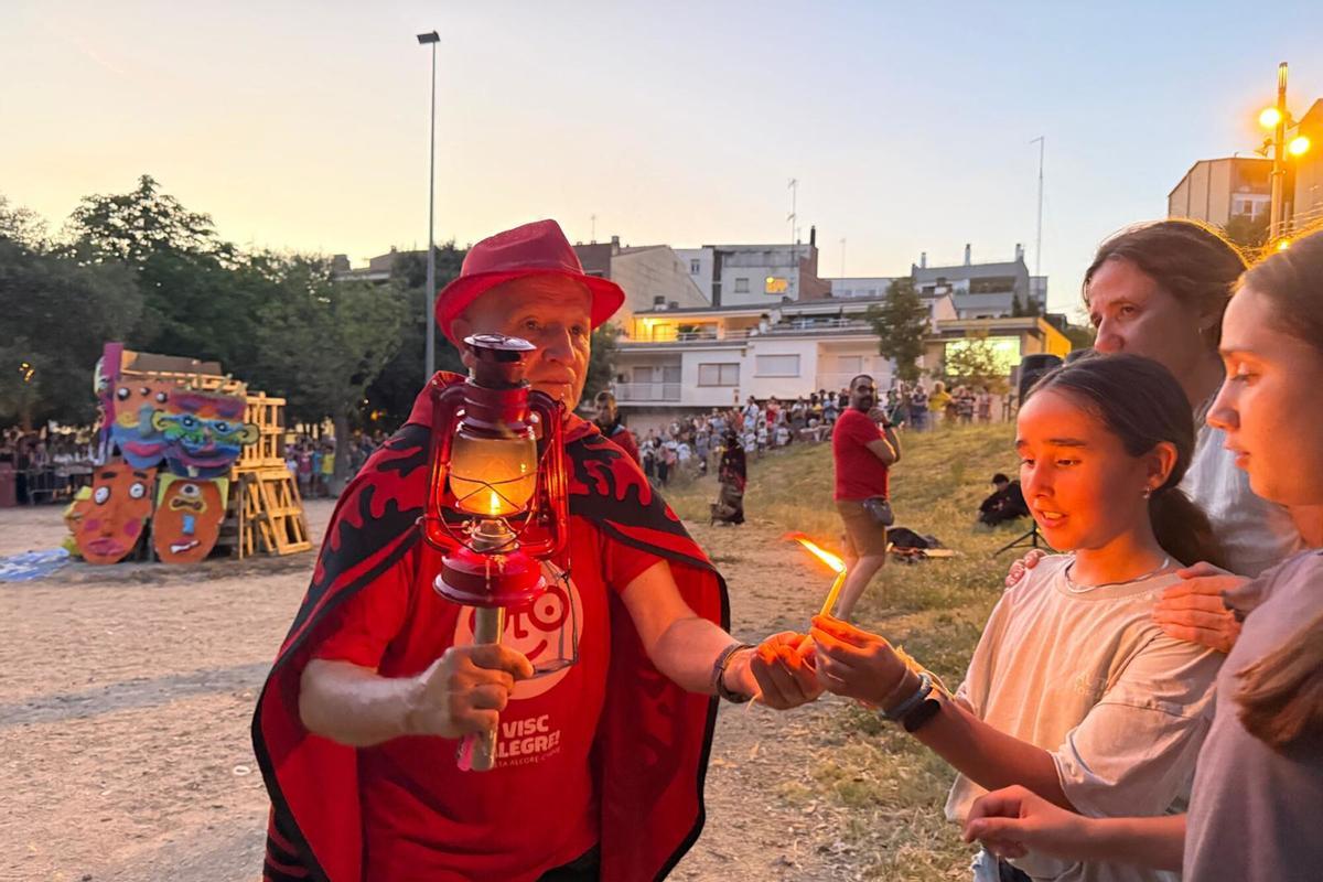 Una nena del barri de Vista Alegre de Girona encenent una espelma amb la flama del Canigo