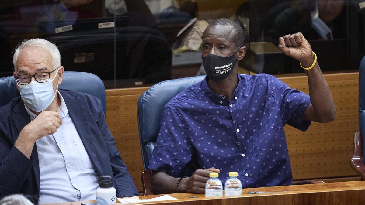 El portavoz del sindicato de manteros y miembro de la Asociación de los Sin Papeles, Serigne Mbaye levanta el brazo para pedir la palabra por alusiones