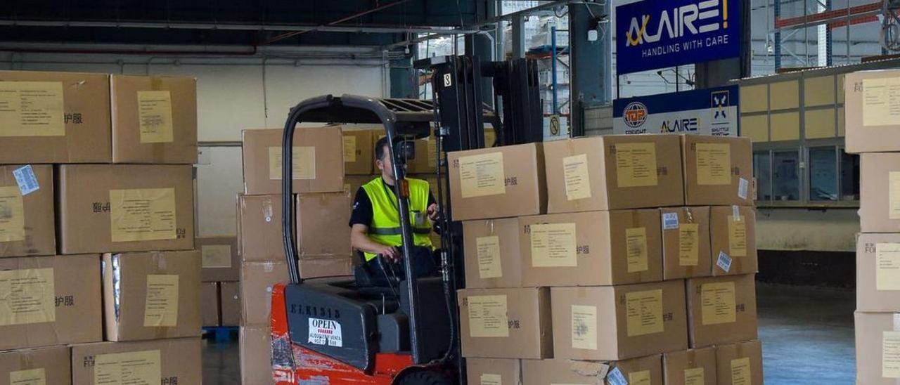 Un operario apila cajas de material sanitario tras desembarcarlas en el aeropuerto de Gran Canaria.